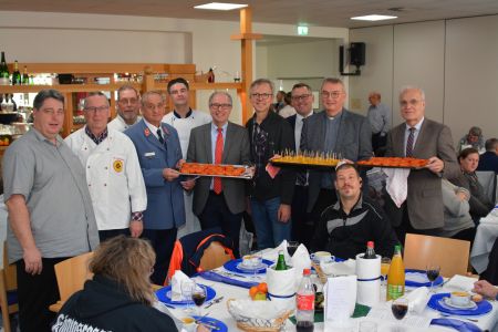 Mittendrin, statt nur vom Rande zugucken zu können – laden Obdachlose zum Weihnachtsessen ein: v. l. Volker Merschmann, Manfred Huschen, Ernst Kuhnt, Franz Kudak, Dirk Tschischke, Landrat Manfred Müller, Joachim Veehnhof (Geschäftsführer SKM), Thorsten Keck (Sparkasse Paderborn), Prälat Thomas Dornseifer und Schulleiter Andreas Czorny zu sehen sind die Beteiligten mit vollen Tabletts auf denen die Speisen angerichtet sind